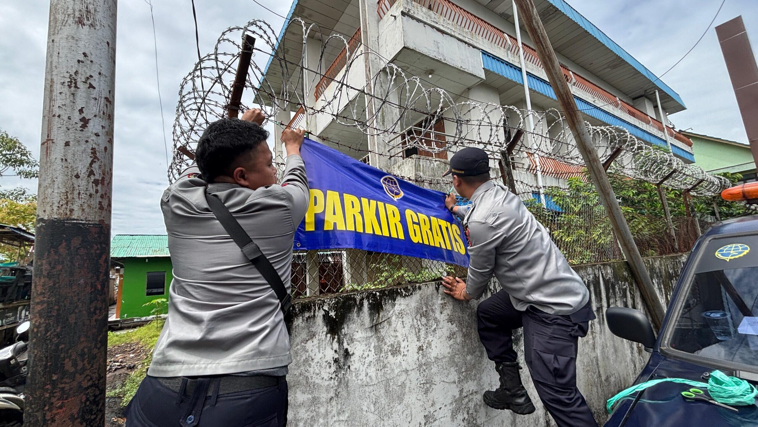 Petugas Dinas Perhubungan Kota Pontianak memasang spanduk Parkir Gratis di lokasi parkir yang tidak berizin.