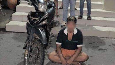 Tersangka AS beserta barang bukti sepeda motor Yamaha Vega hasil curian, Jumat (14/11/2025).